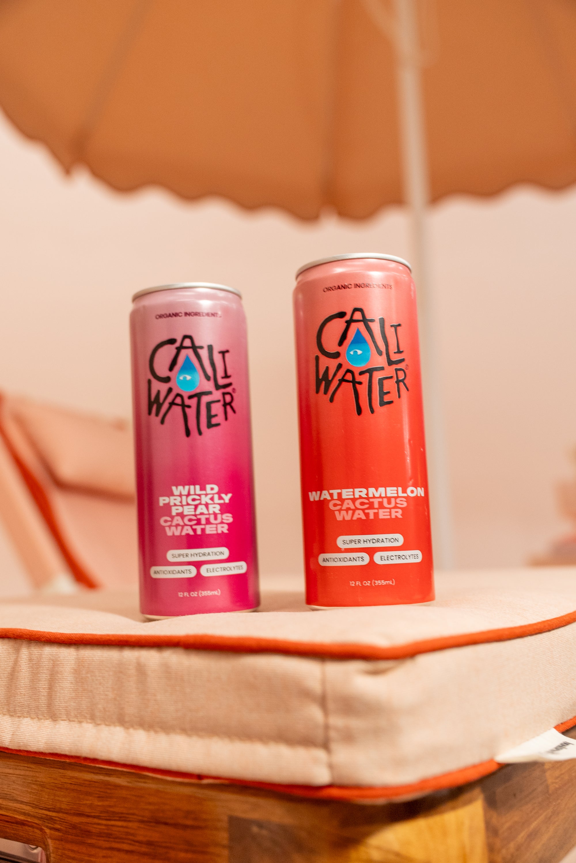 Caliwater cans on a sun lounger beneath an umbrella